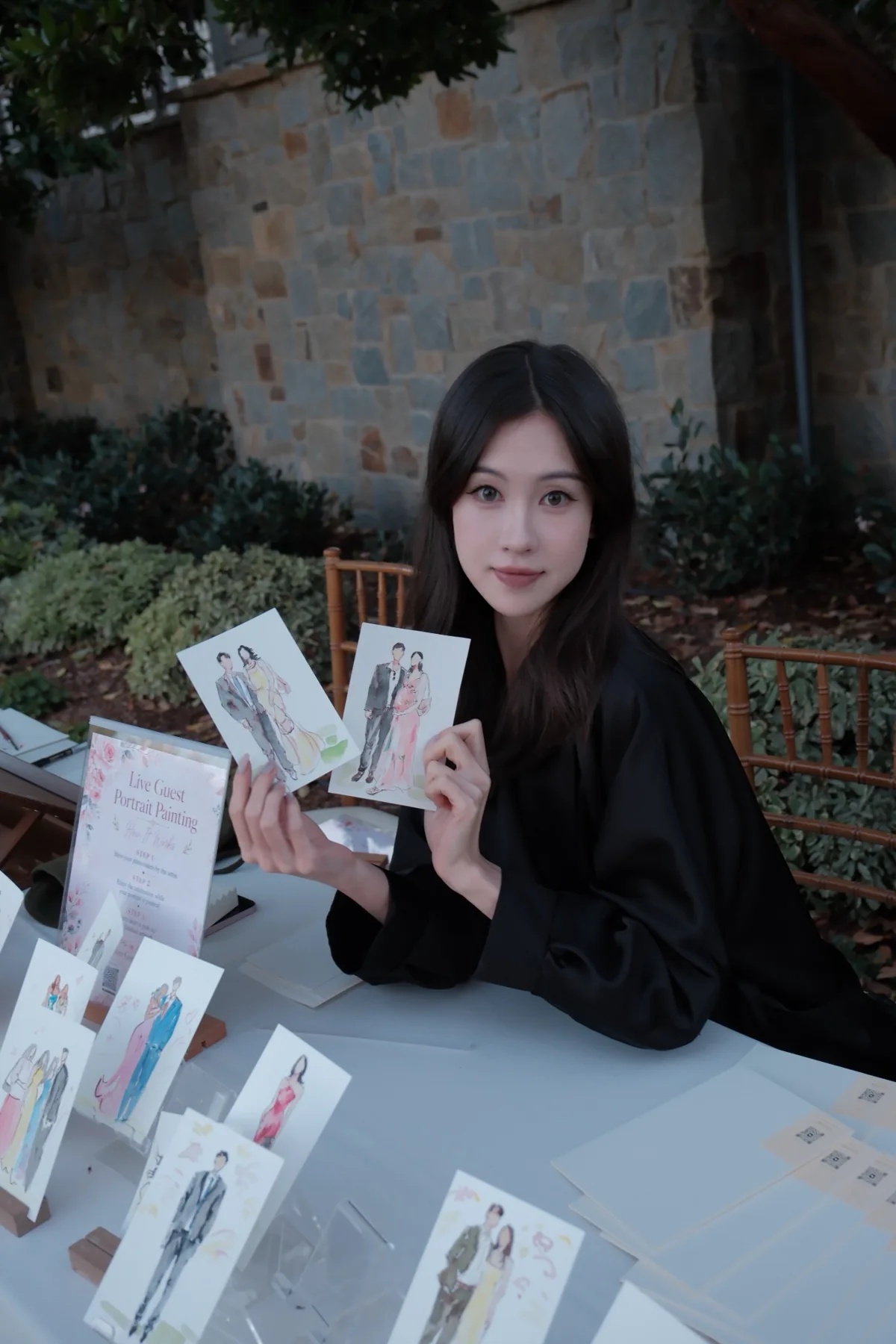 Hannah presenting her hand-painted guest fashion sketches at a wedding
