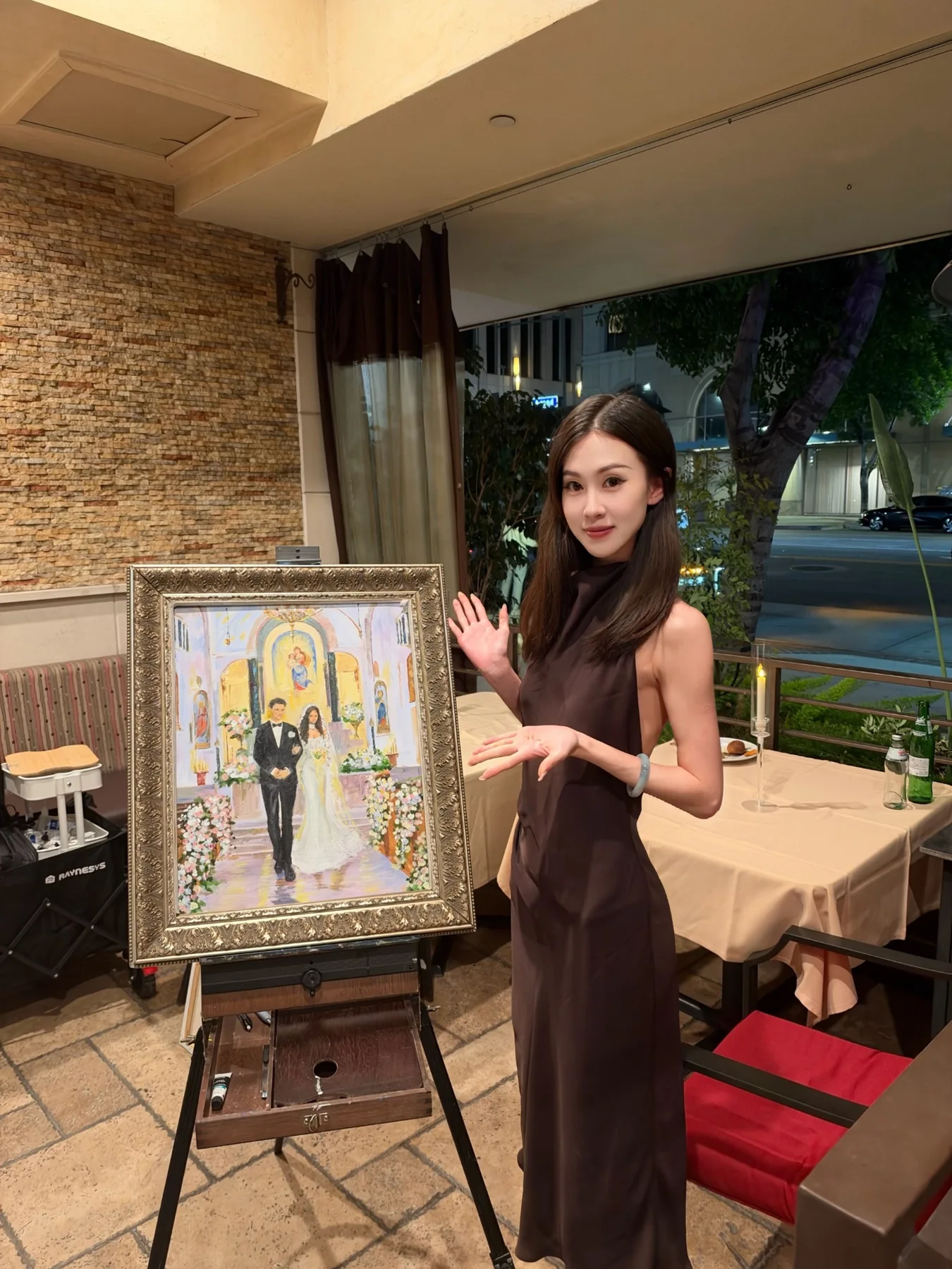 Hannah beside a framed live wedding painting